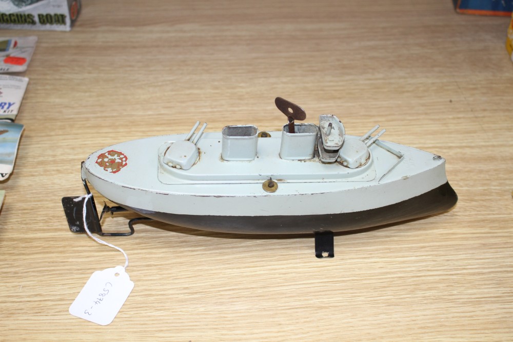 A Sutcliffe Valiant enamelled metal model battleship, clockwork with key and stand, unboxed